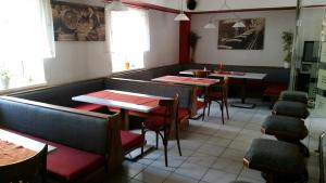 um restaurante com mesas e cadeiras num quarto em Makss em Wels