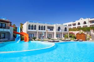 a swimming pool with a water slide in front of a building at Sunrise Arabian Beach Resort in Sharm El Sheikh