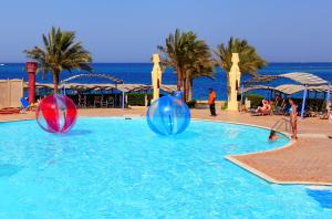 a swimming pool with two balls in the water at Sphinx Aqua Park Beach Resort in Hurghada