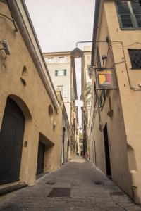 an empty alley with buildings and a sign on a building at Manena Hostel Genova in Genova