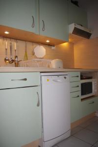 a kitchen with a white refrigerator and a microwave at Maison à ROYAN PONTAILLAC in Royan