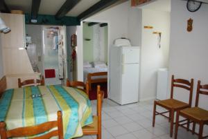 a room with a bed and chairs and a refrigerator at Maison à ROYAN PONTAILLAC in Royan