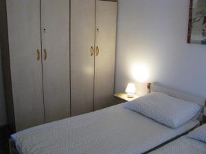 1 dormitorio con armarios blancos, 1 cama y 1 lámpara en Hiša marjetica, en Maribor