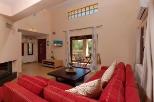 uma sala de estar com um sofá vermelho e uma mesa em Evalexia em Kalamaki