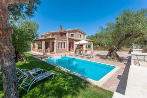 an estate with a swimming pool and a house at Evalexia Villa in Kalamaki