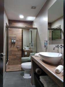 ein Bad mit einem Waschbecken, einem WC und einer Dusche in der Unterkunft Remfort Hotel in Santa Ana