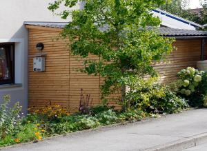 a house with a wooden wall with flowers on it at Hotel Garni Möwe in Tutzing