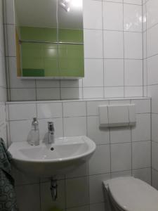 a white bathroom with a sink and a toilet at Ferienwohnung Wössner in Oberndorf