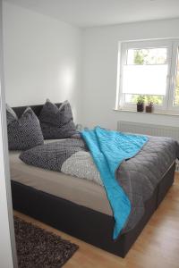 a bed with a blue blanket on it in a bedroom at Ferienwohnung Wössner in Oberndorf