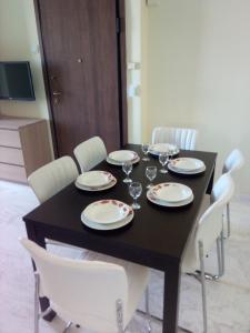 a black table with white chairs and wine glasses on it at Apartment Elena in Piraeus