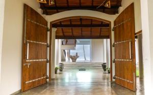 um corredor aberto com duas grandes portas de madeira em Villa Océane em Mirissa