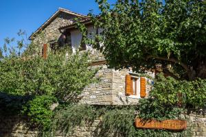 kamienny budynek z drzewem przed nim w obiekcie Holiday Home Casa Dei Farfui w mieście Momjan