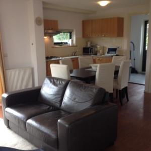 a living room with a leather couch and a table and chairs at Vacation Home 72 in Tzummarum