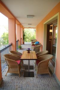 um pátio com cadeiras e uma mesa de madeira numa varanda em Residence La Meridiana em Galzignano