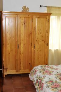 a bedroom with a wooden cabinet next to a bed at Cottage Abetone La Capanna in Tuscany in Abetone