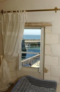 a bedroom with a window with a view of the ocean at Le Corps de Garde in Saint-Martin-de-Ré