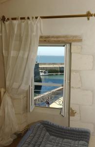 a bedroom with a window with a view of the ocean at Le Corps de Garde in Saint-Martin-de-Ré