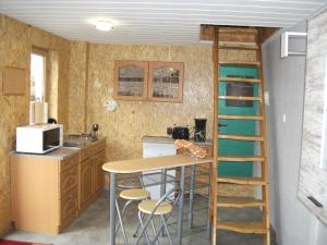 una pequeña cocina con una mesa y una escalera en Kleine Ferienwohnung en Barth