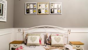 a bedroom with a white bed with three pictures on the wall at Amando Bucharest in Bucharest