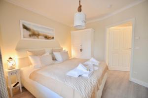 een slaapkamer met een groot wit bed in een kamer bij Villa Strandblick 5 in Zingst