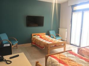 Pokój z dwoma łóżkami i telewizorem na ścianie w obiekcie Résidence Universitaire Lanteri w mieście Fontenay-aux-Roses