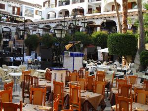 een openluchtrestaurant met tafels en stoelen en een gebouw bij Jardin de Alba in Villacosta