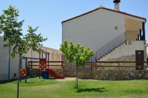 einen Spielplatz in einem Hof neben einem Gebäude in der Unterkunft Rural Reillo Alojamientos Rurales in Reíllo