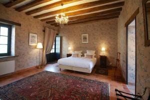 um quarto com uma cama e um lustre em maison d'hôtes de l'orangerie 14 personnes em Azay-sur-Cher