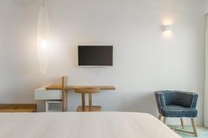 a bedroom with a bed and a desk and a tv at Semeli in Kokkari
