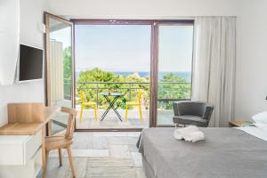 a bedroom with a bed and a view of a balcony at Semeli in Kokkari