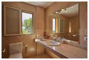 ein Badezimmer mit Waschbecken, Toilette und Spiegel in der Unterkunft Ca Ses Nines in Inca
