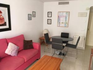 ein Wohnzimmer mit einem roten Sofa und einem Tisch in der Unterkunft Apartamento en Calpe, playa de La Fossa, primera línea, AA in Calpe