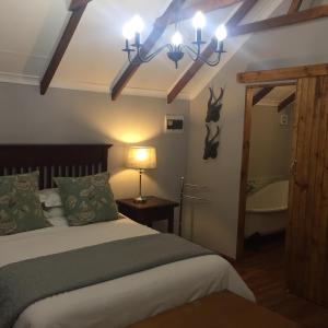 a bedroom with a bed and a bathroom with a tub at De Witte Loft in Newcastle