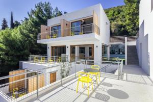 a house with a balcony with yellow chairs at Semeli in Kokkari