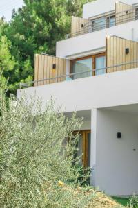 a white house with trees in front of it at Semeli in Kokkari