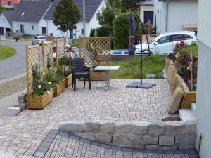 eine Terrasse mit einem Tisch und Stühlen im Hof in der Unterkunft Ferienwohnung Sonne 11 in Weisbrunn