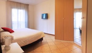 a bedroom with a bed and a tv on a wall at Como's Lake Mountains B&B in Cremeno