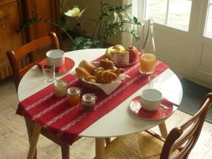 einen Tisch mit einem Frühstück mit Brot und Orangensaft in der Unterkunft Stretcha in Châteaubourg