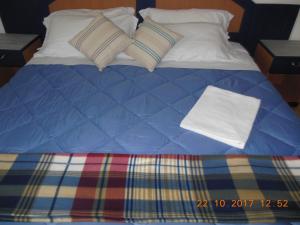 カザーレ・スル・シーレにあるLocanda Ponte Stella al Borgoのベッド(青い掛け布団、枕付)