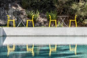 three yellow chairs and a pool of water at Semeli in Kokkari