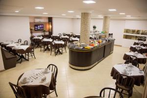 Dois VizinhosにあるDois Vizinhos Palace Hotelのテーブルと椅子のあるレストラン、バー