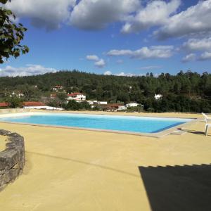 a large swimming pool on a sandy beach at Casa na Quinta de Valinhas in Vitorino dos Piães