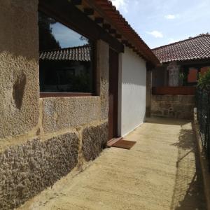 ein Gebäude mit einer Steinmauer und einem Gehweg in der Unterkunft Casa na Quinta de Valinhas in Vitorino dos Piães