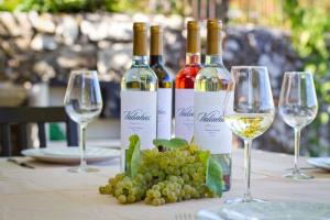 three bottles of wine sitting on a table with wine glasses at Casa na Quinta de Valinhas in Vitorino dos Piães