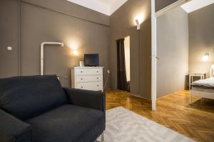 een woonkamer met een bank en een bed bij Logement Sous le Château in Boedapest