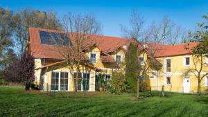 a large yellow house with a red roof at Salzingerhof in Kirchdorf am Inn