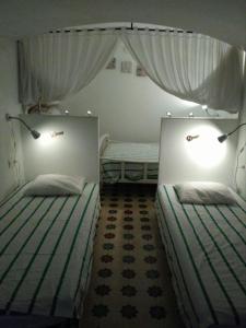 2 camas individuales en una habitación con cortinas en Casa Petra, en Arcos de la Frontera