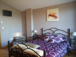 1 dormitorio con 1 cama con edredón morado en Apartamento Golf Buenas Vistas, en Cirueña