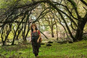 Una donna con un cappello in piedi in una foresta di Ludwig Guesthouse a Lagodekhi