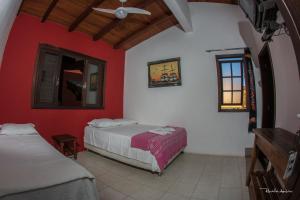 a bedroom with two beds and a ceiling fan at Pousada Villa Prainha in Farol de Santa Marta +34 photos